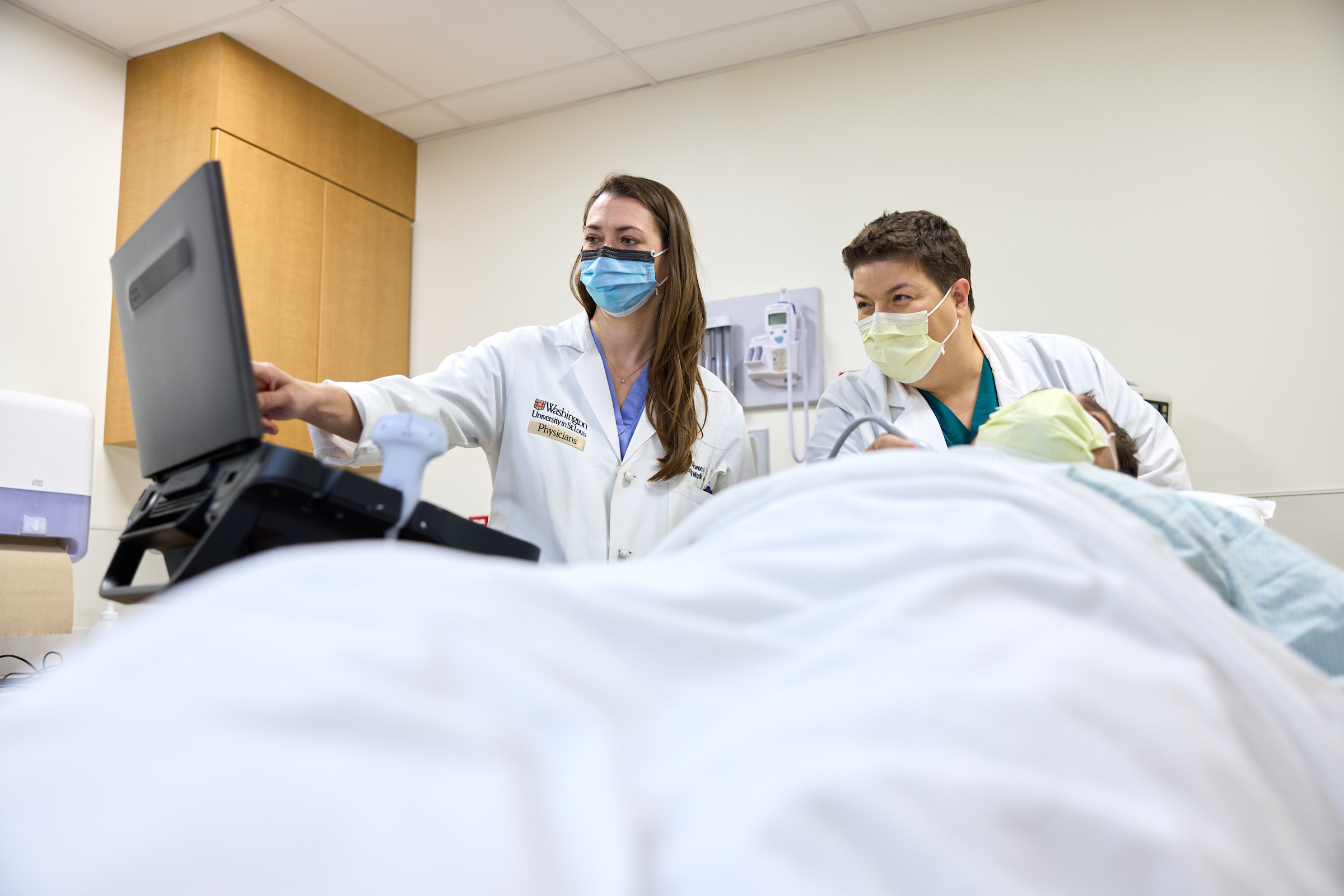 Stephanie Conner, MD, and Crystal Atwood, MD, use POCUS (point of care ultrasound) on a staff member posing as a patient at Barnes-Jewish Hospital